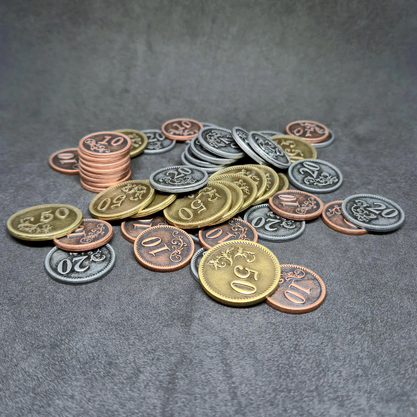 Set of bronze, silver and gold metal coins of value 10, 20, and 50 for board games