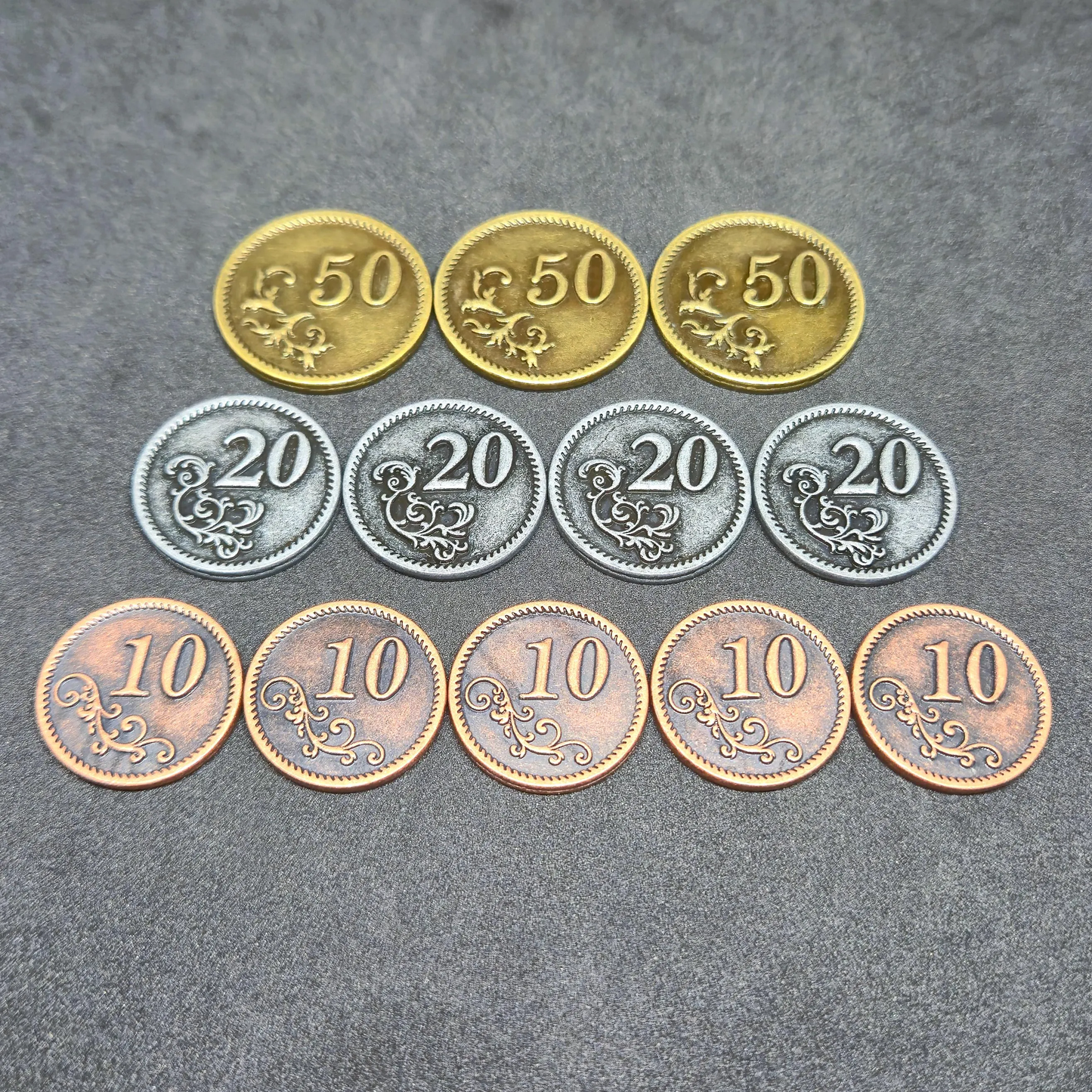 Set of bronze, silver and gold metal coins of value 10, 20, and 50 for board games