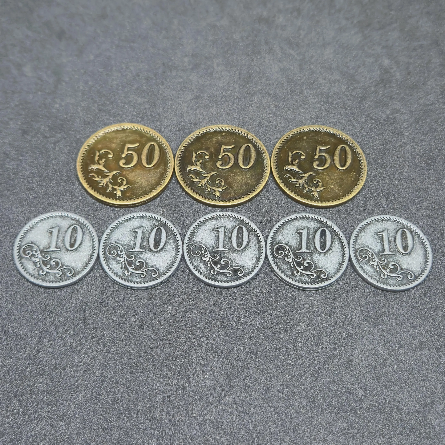 Set of silver and gold metal coins of value 10 and 50 for board games